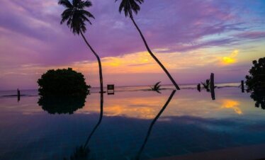 Doubletree by Hilton infinity pool reflecting a sunset sky