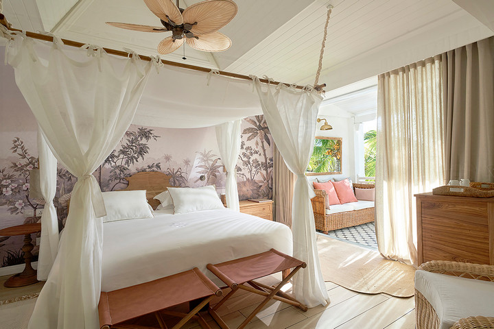 Elegant bedroom with a canopy bed and tropical design at Paradise Cove Boutique