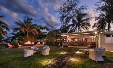 Evening ambiance at Solana Beach with outdoor seating firepit and tropical surroundings