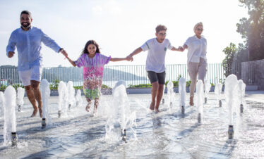 Family running through fountains having fun at Canopy by Hilton