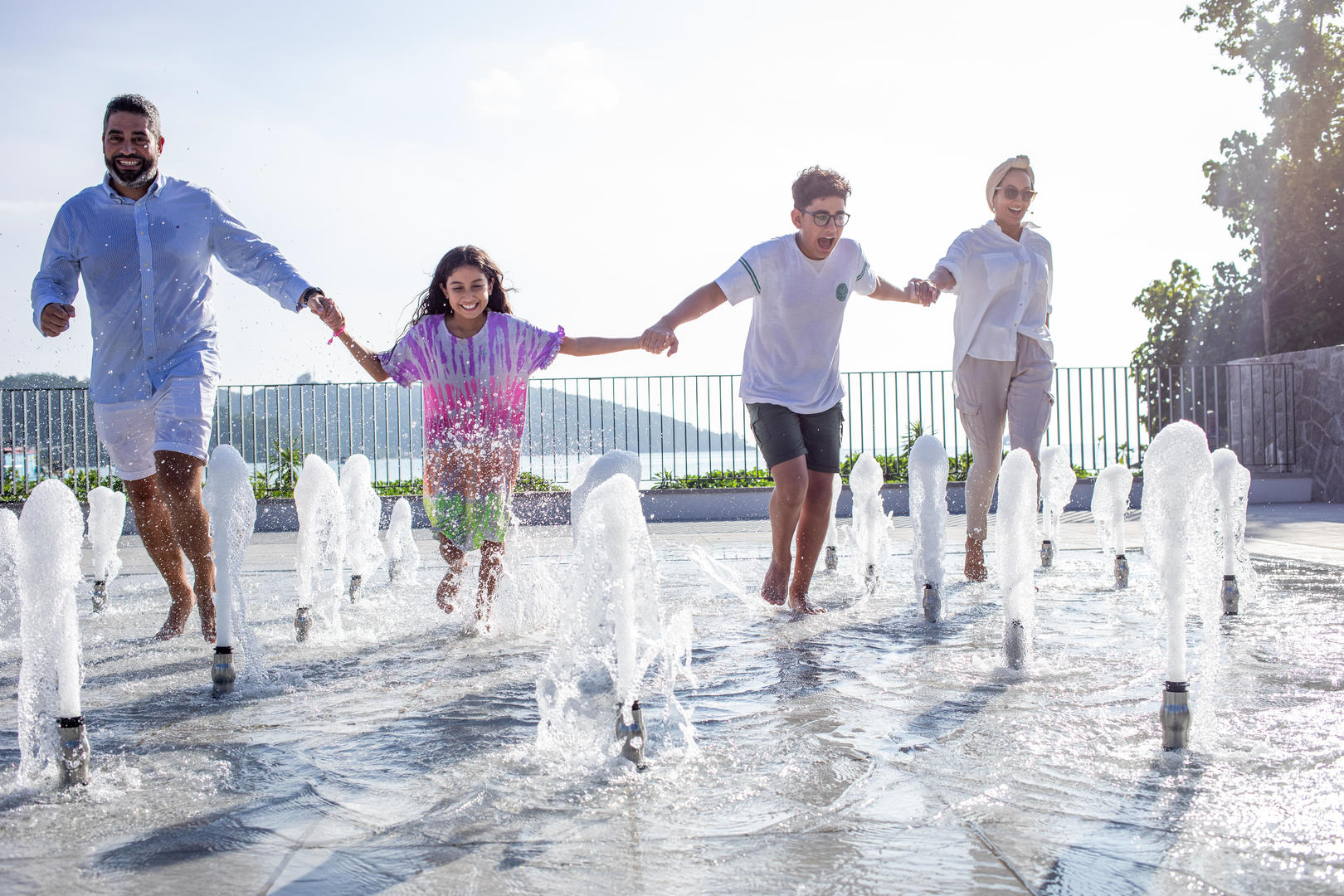 Family running through fountains having fun at Canopy by Hilton