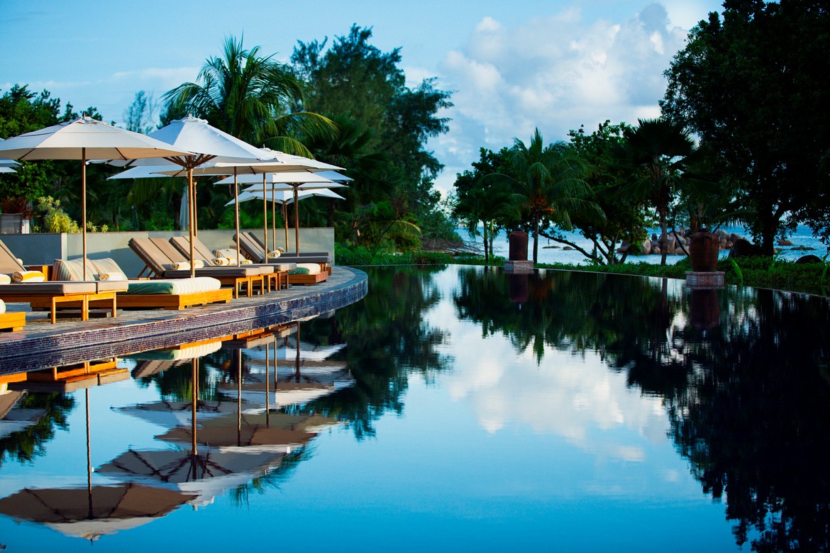 Infinity pool at Raffles Praslin reflecting the tropical sky