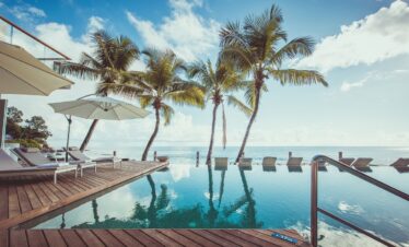 Infinity pool with palm trees at Carana Beach Hotel