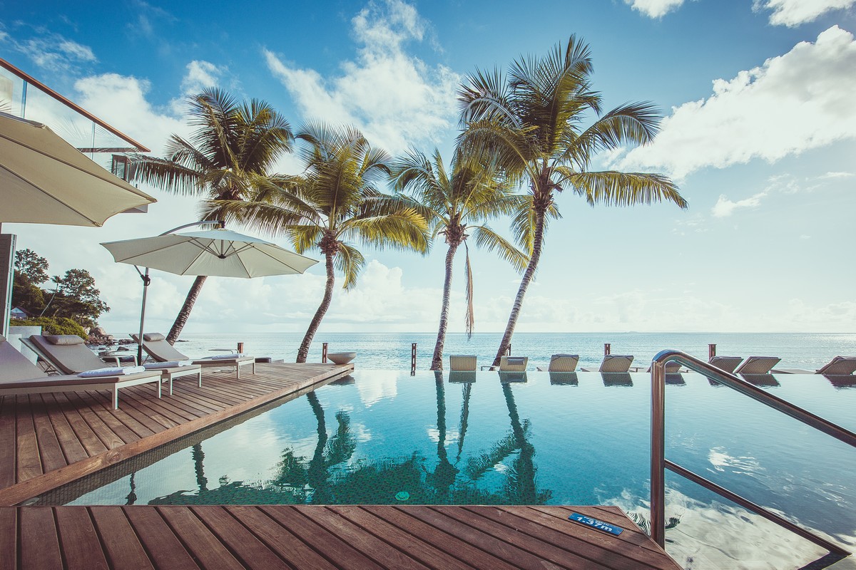 Infinity pool with palm trees at Carana Beach Hotel