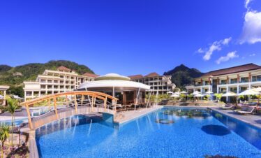 Large swimming pool at Savoy Seychelles with sun loungers
