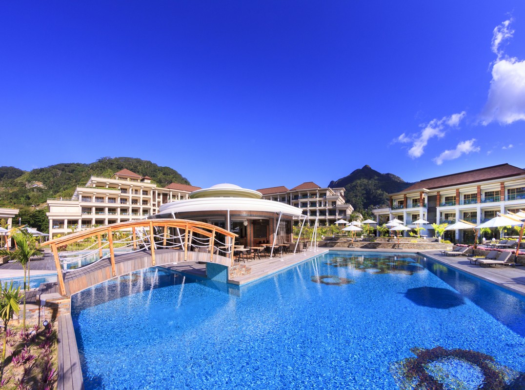 Large swimming pool at Savoy Seychelles with sun loungers