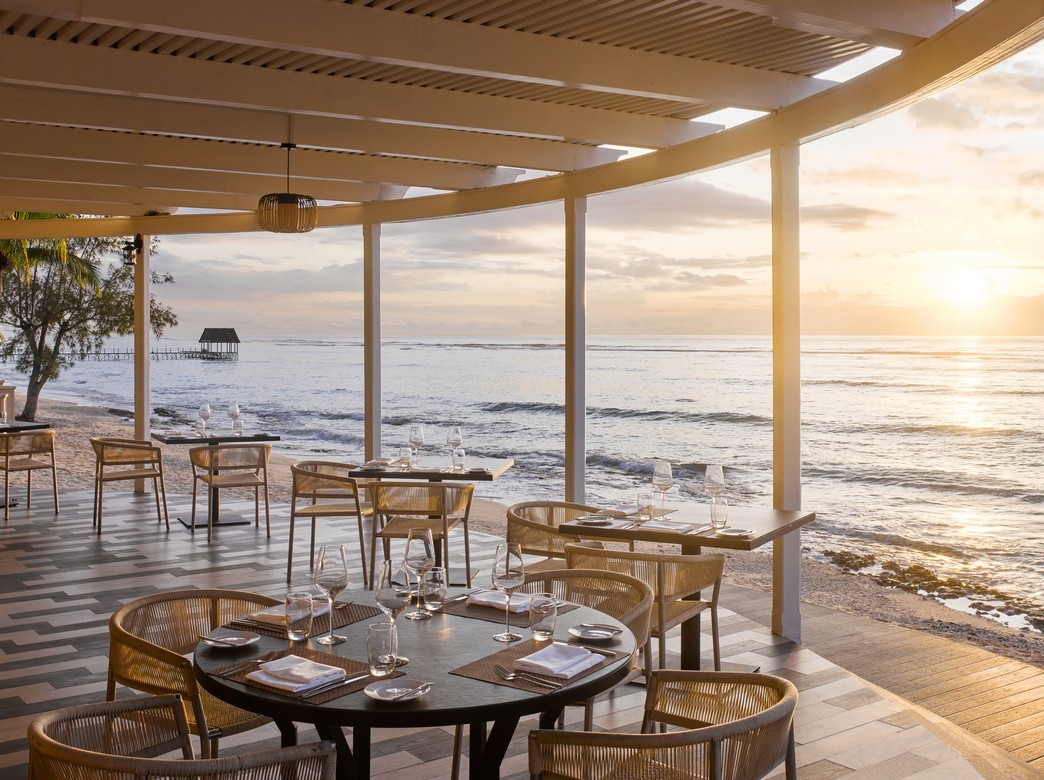 Oceanfront dining area at sunset at Nirvana At Le Meridien Ilse Mauritius offering serene views