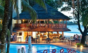 Poolside bar at Coral Strand Hotel Seychelles with evening lights