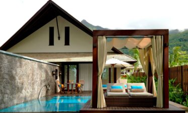 Poolside relaxation area in a resort featuring a cabana and lounge chairs Story of tranquil luxury