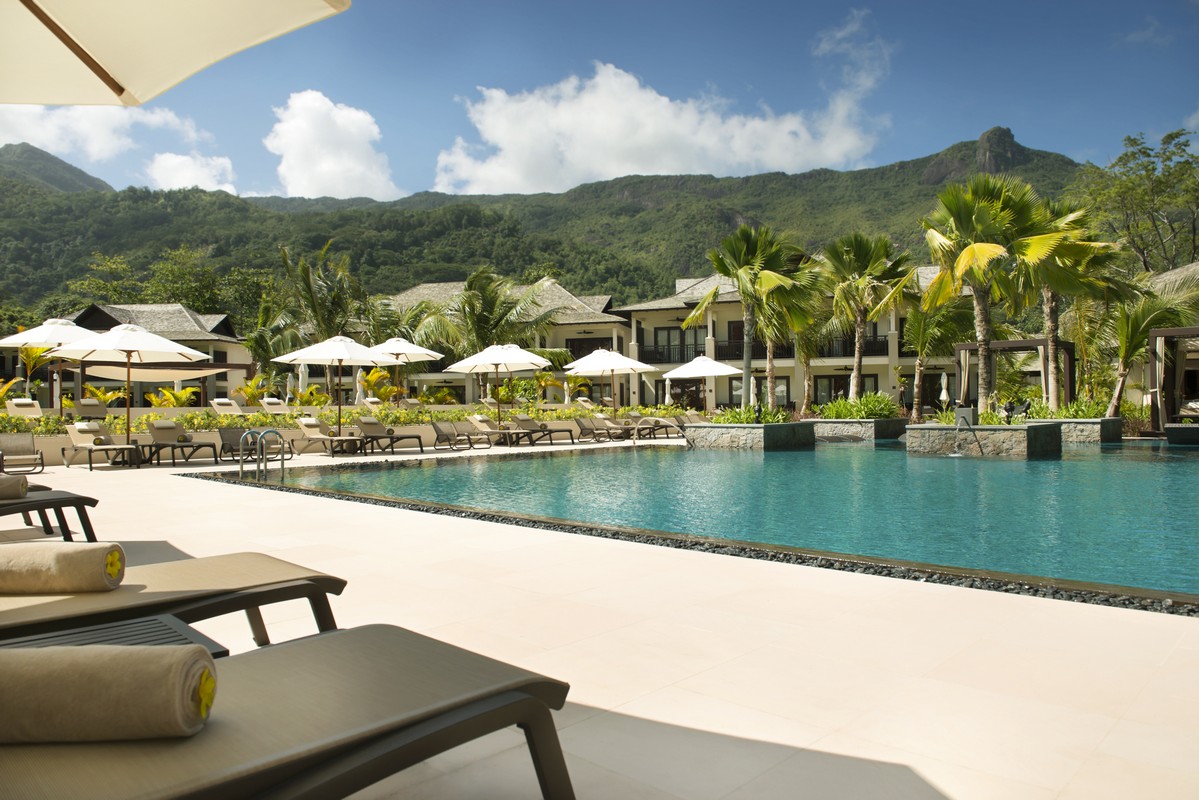 Resort pool area with mountain views palm trees and comfortable loungers Story of serene poolside relaxation