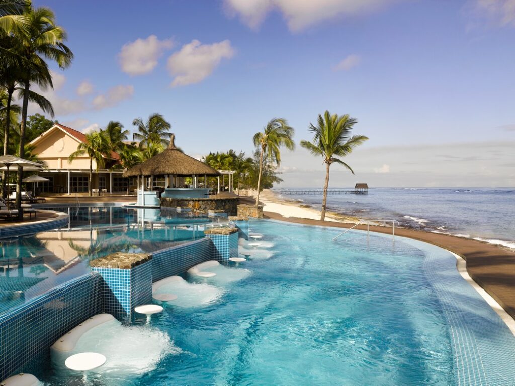Resort poolside with palm trees at Nirvana At Le Meridien Ilse Mauritius providing a relaxing atmosphere