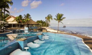 Resort poolside with palm trees at Nirvana At Le Meridien Ilse Mauritius providing a relaxing atmosphere