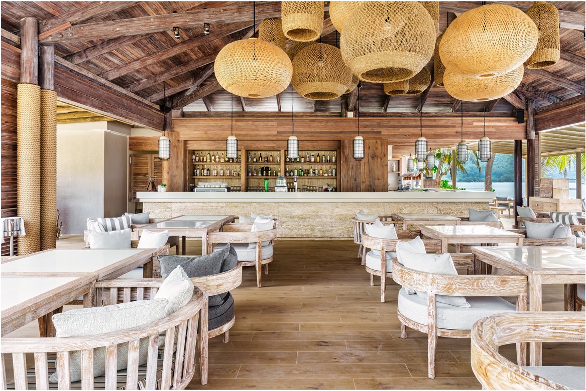 Rustic beachfront bar at Kempinski Seychelles Resort with ocean view
