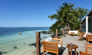 Scenic oceanfront seating at Solana Beach with wooden chairs and palm trees by the water