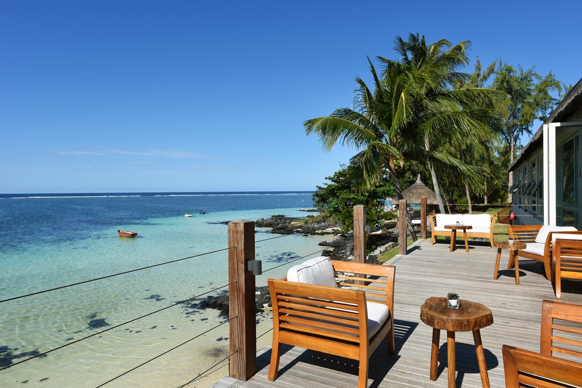 Scenic oceanfront seating at Solana Beach with wooden chairs and palm trees by the water