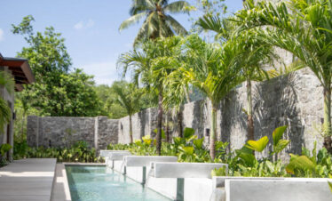 Serene outdoor pool area at Canopy by Hilton surrounded by greenery