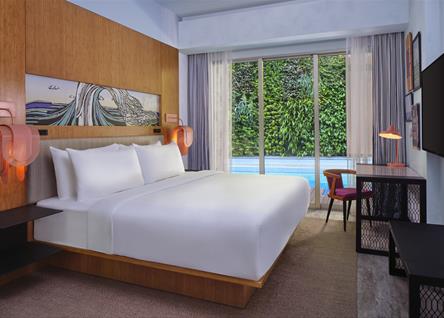 Spacious ALOFT BALI suite with elegant furnishings and a pool view