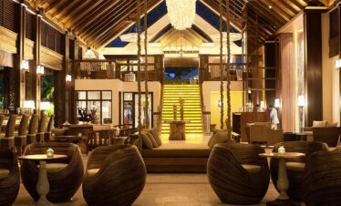 Story of a luxurious lobby with warm lighting and modern wooden furniture in an elegant resort setting