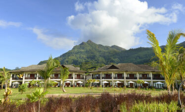 Story of a resort with a stunning mountain backdrop showcasing well-maintained lawns and modern accommodations