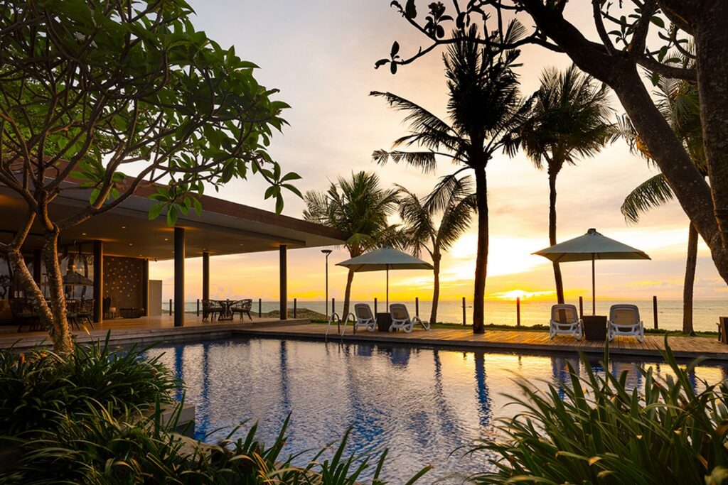 Sunset view by the pool at The Anvaya Bali with palm trees