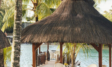 Thatched roof dining area at Paradise Cove Boutique by the waterfront
