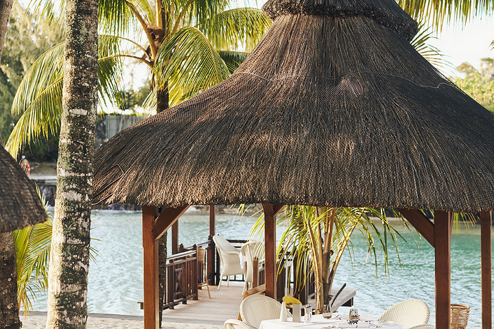 Thatched roof dining area at Paradise Cove Boutique by the waterfront
