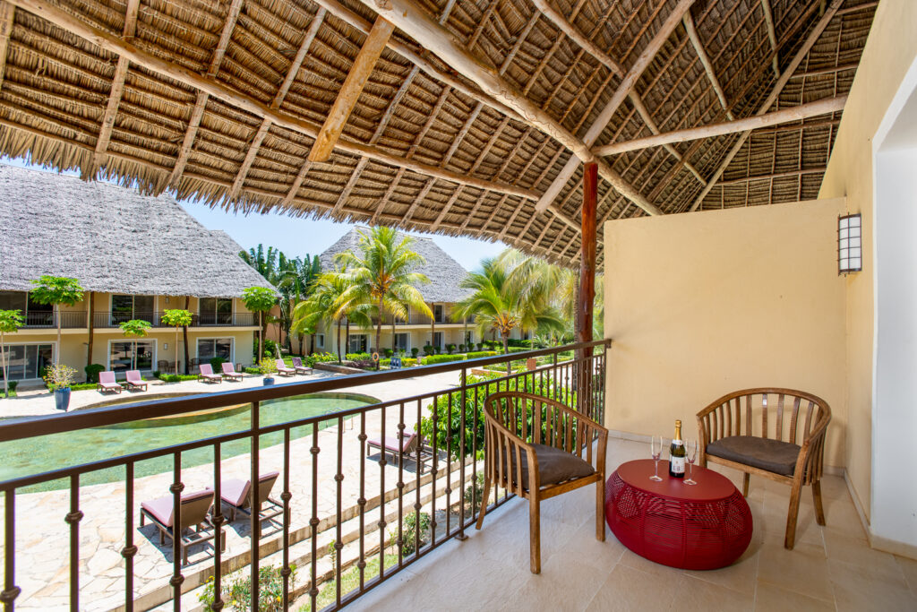 Balcony view at Tui Blue Bahari with wooden chairs and table overlooking pool