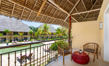 Balcony view at Tui Blue Bahari with wooden chairs and table overlooking pool