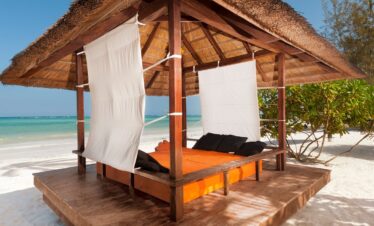 Beachfront cabana at Melia Zanzibar with a shaded daybed on the sand