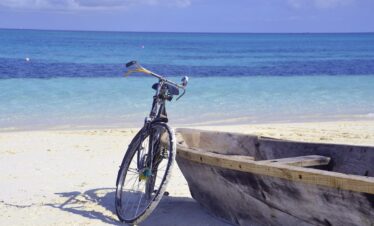 Bicycle and wooden boat resting on the sandy shores of Gold Zanzibar