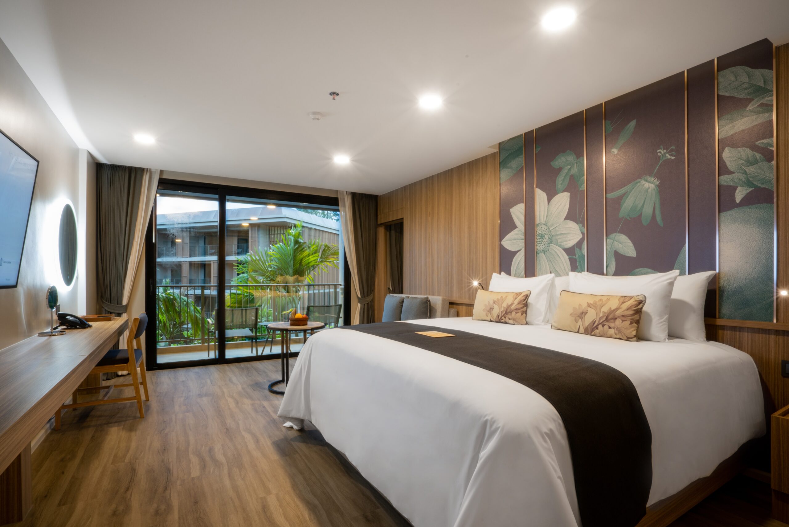 Comfortable king sized bed in a stylish room with a balcony view at La Flora Khao Lak