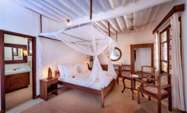 Cozy bedroom at Diamonds Mapenzi Beach Resort with traditional decor