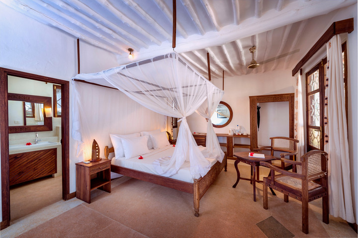 Cozy bedroom at Diamonds Mapenzi Beach Resort with traditional decor