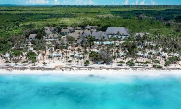Diamonds Mapenzi Beach Resort aerial view of beachfront villas and palm trees