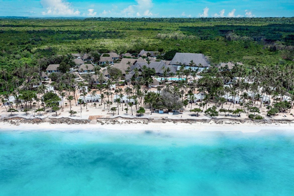 Diamonds Mapenzi Beach Resort aerial view of beachfront villas and palm trees