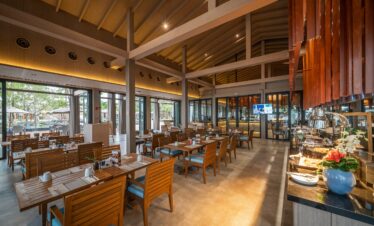 Elegant dining area with wooden furniture and open space design at La Flora Khao Lak