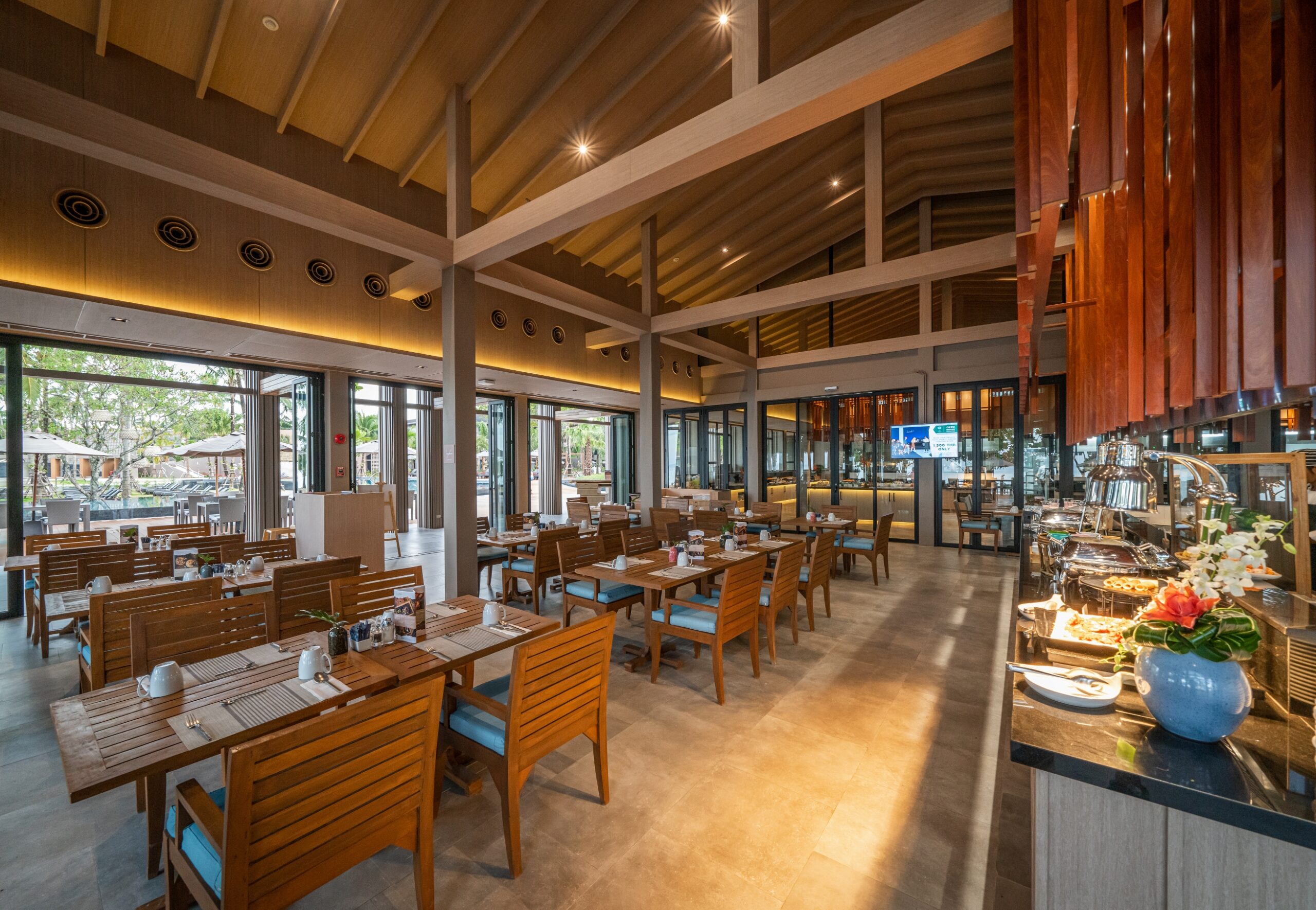 Elegant dining area with wooden furniture and open space design at La Flora Khao Lak