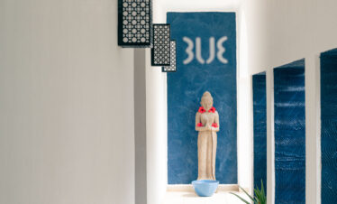 Hallway with a Buddha statue and blue accents at Tui Blue Bahari