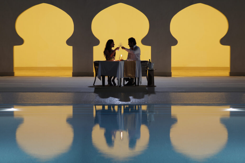 Intimate candlelit dinner setup by the pool at Gold Zanzibar resort