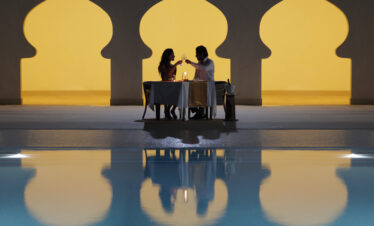 Intimate candlelit dinner setup by the pool at Gold Zanzibar resort
