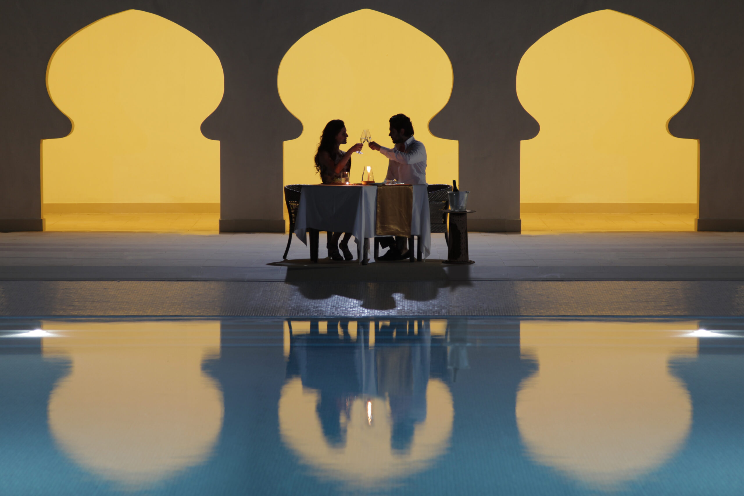 Intimate candlelit dinner setup by the pool at Gold Zanzibar resort