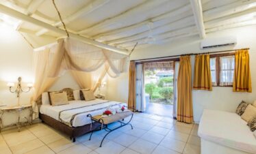 Karafuu Beach Resort tropical suite with canopy bed and garden view