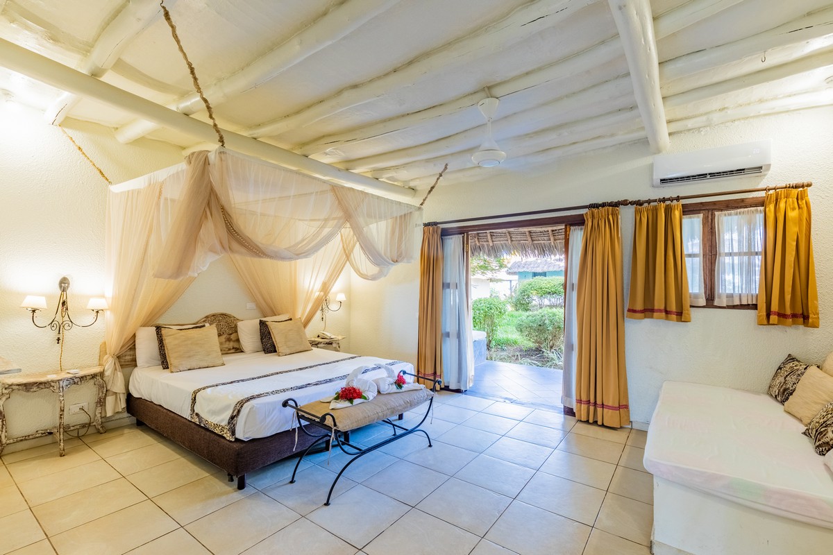 Karafuu Beach Resort tropical suite with canopy bed and garden view