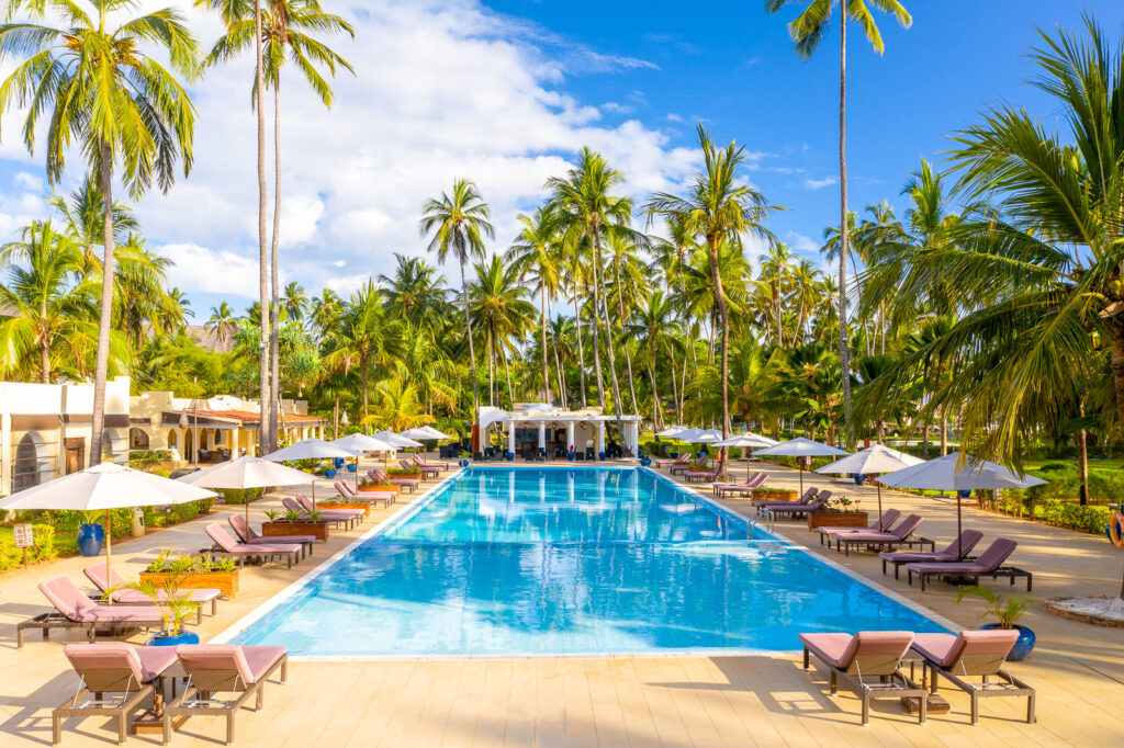 Large outdoor swimming pool surrounded by palm trees and sun loungers at Tui Blue Bahari