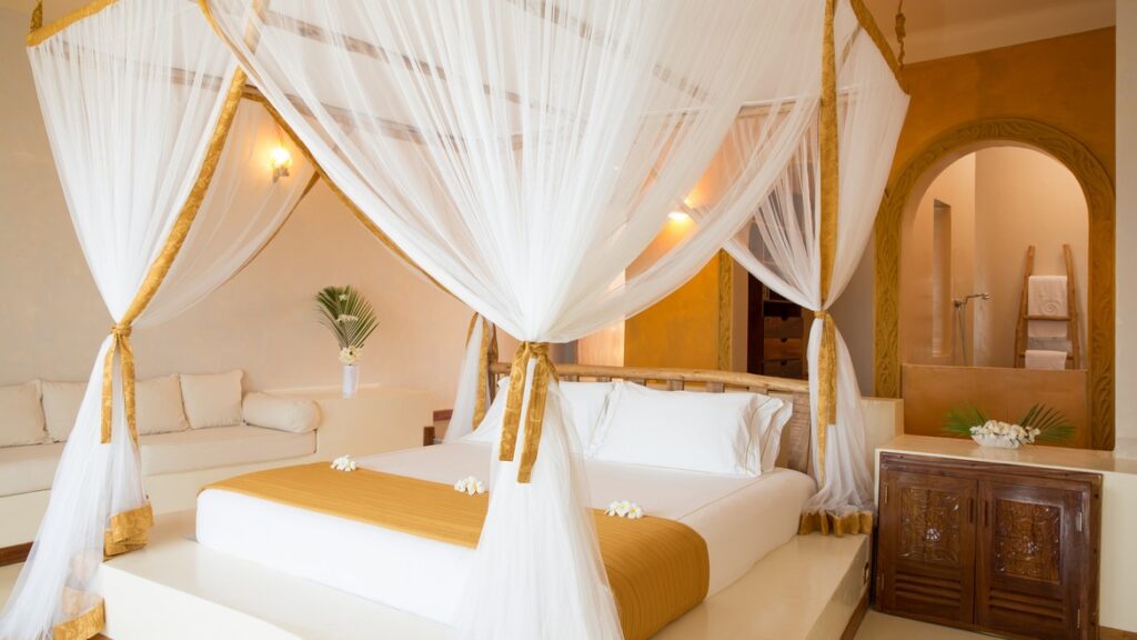 Luxurious bed with a canopy in a suite at Gold Zanzibar resort