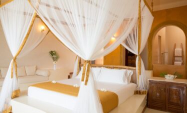 Luxurious bed with a canopy in a suite at Gold Zanzibar resort