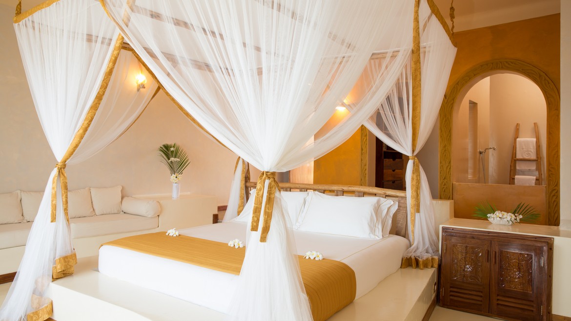 Luxurious bed with a canopy in a suite at Gold Zanzibar resort