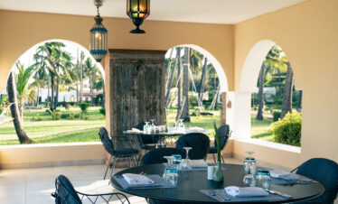 Outdoor dining area with garden view at Tui Blue Bahari featuring lantern-style lights