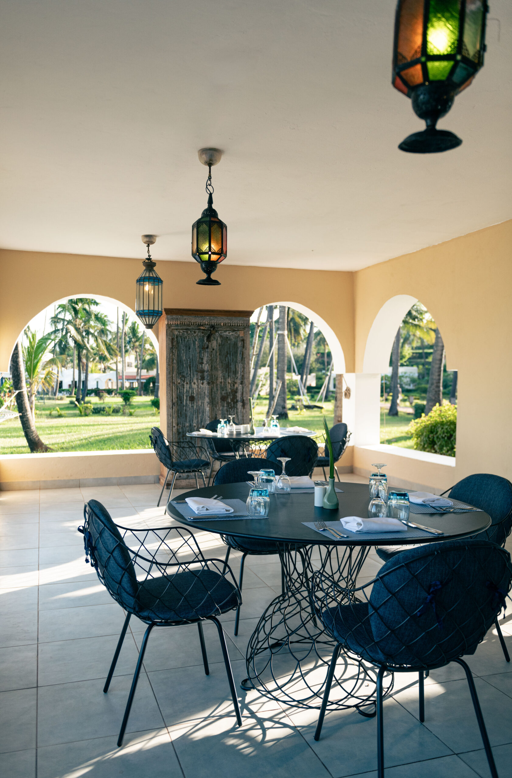 Outdoor dining area with garden view at Tui Blue Bahari featuring lantern-style lights