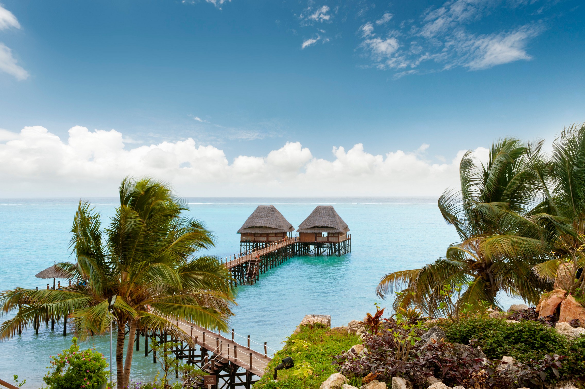 Overwater bungalows at Melia Zanzibar surrounded by blue waters